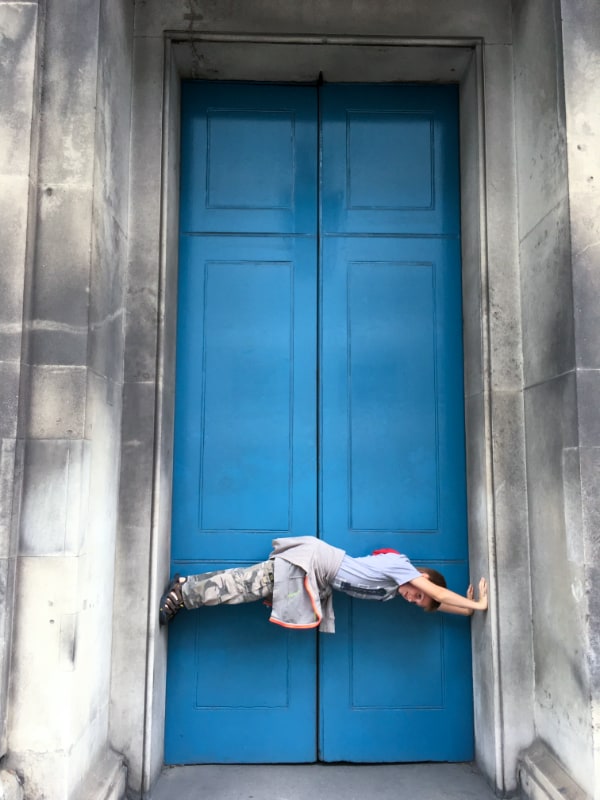 Child Sideways In A Doorway.